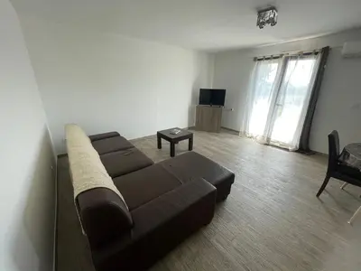 a living room with a brown couch and a table at U Primu Appartement spacieux au calme Aléria in Aléria