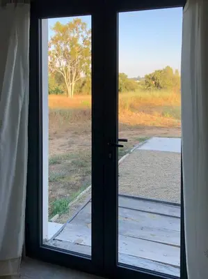 an open door with a view of a field at U Primu Appartement spacieux au calme Aléria in Aléria