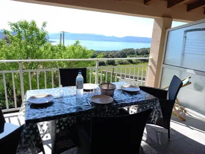 a table on a balcony with a view of the ocean at CASA DI PETRU ANTÒ in Serra-di-Ferro