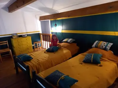 a little girl sitting in a room with three beds at CASA DI PETRU ANTÒ in Serra-di-Ferro