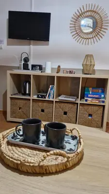 a table with two cups on a tray in a living room at mini villa 72, résidence avec piscine. in Serra-di-Ferro