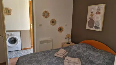 a bedroom with a bed and a washing machine at mini villa 72, résidence avec piscine. in Serra-di-Ferro