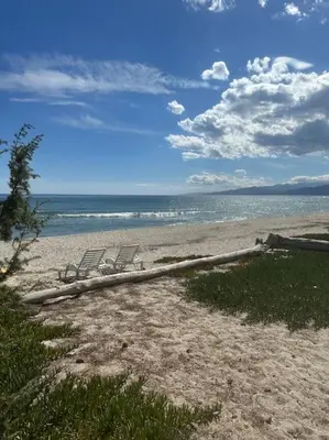 two chairs sitting on a beach near the water at Maison les pieds dans l’eau in Ghisonaccia