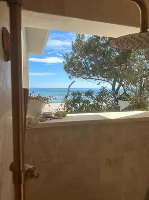 a view of the ocean from a bathroom window at Maison les pieds dans l’eau in Ghisonaccia