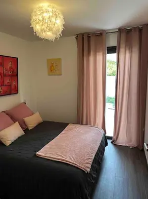 a bedroom with a black bed and a chandelier at Maison les pieds dans l’eau in Ghisonaccia