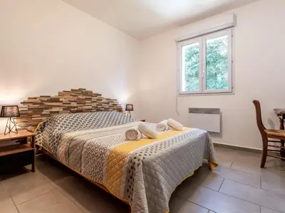 a bedroom with a bed and a table and a window at Holiday Home Casa Brigitte by Interhome in Sainte-Lucie de Porto-Vecchio