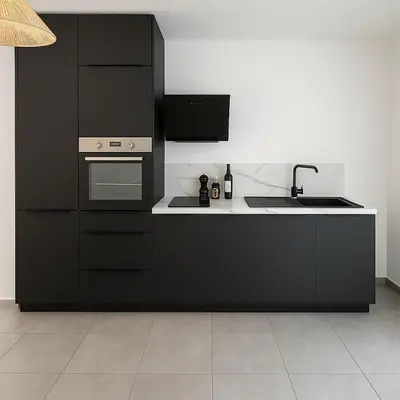 a kitchen with black cabinets and a sink at Résidence Arborea C4 corte in Corte