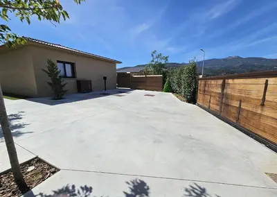 a driveway in front of a house with a fence at Résidence Villas Chléa in Lucciana