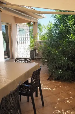 a table and chairs on a patio with plants at Villa tout confort avec piscine privée in Ventiseri