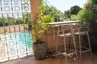 a patio with a table and chairs next to a fence at Villa tout confort avec piscine privée in Ventiseri