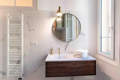 a bathroom with a sink and a mirror on the wall at Appartement Ajaccien familial in Ajaccio