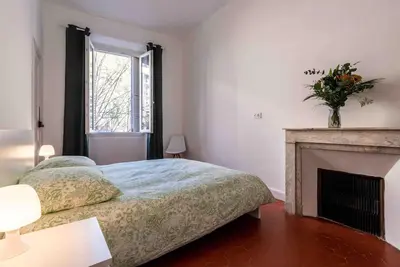 a bedroom with a bed and a fireplace at Appartement Ajaccien familial in Ajaccio