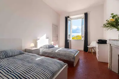 a bedroom with two beds and a window at Appartement Ajaccien familial in Ajaccio