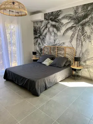 a bedroom with a large bed with a palm mural at Studio 173 - Ajaccio - Campagne in Ajaccio