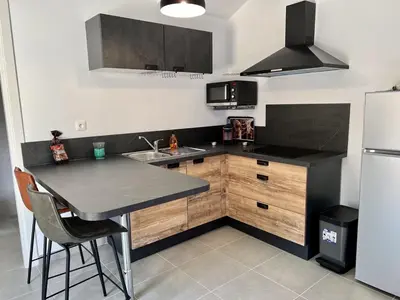 a kitchen with a table and a refrigerator at Studio 173 - Ajaccio - Campagne in Ajaccio