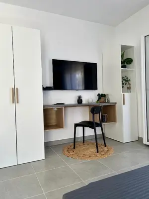 a room with a chair and a flat screen tv at Studio 173 - Ajaccio - Campagne in Ajaccio
