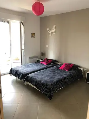 a bedroom with a bed with a butterfly on the wall at Location F2 classée 3 étoiles pour des vacances de rêve in San-Nicolao