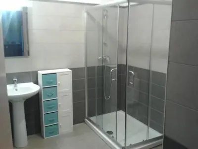 a bathroom with a glass shower and a sink at Location F2 classée 3 étoiles pour des vacances de rêve in San-Nicolao