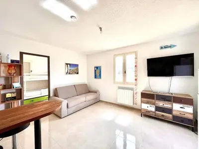 a living room with a couch and a flat screen tv at Appartement 2 chambres à Lama avec Piscine in Lama