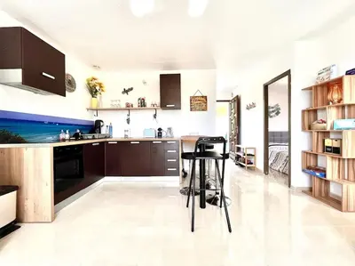 a kitchen with brown cabinets and a counter top at Appartement 2 chambres à Lama avec Piscine in Lama