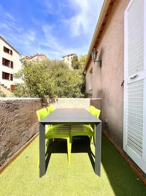 a table and chairs sitting on a patio at Appartement 2 chambres à Lama avec Piscine in Lama