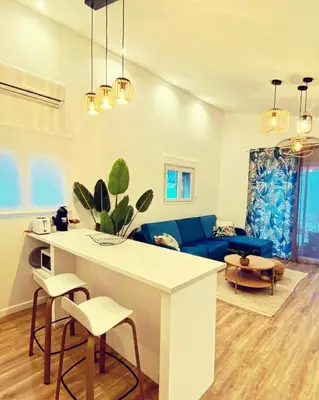 a kitchen and living room with a blue couch at Mini Villa Indépendante à 350m de la mer (LAX) in Lucciana