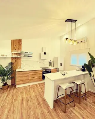 a large kitchen with a white counter and a table at Mini Villa Indépendante à 350m de la mer (LAX) in Lucciana