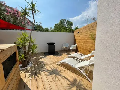 a patio with white chairs on a wooden deck at Mini Villa Indépendante à 350m de la mer (LAX) in Lucciana