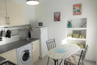a small kitchen with a table and a washing machine at Appartement Chiola-Plage à pieds-clim in Solaro