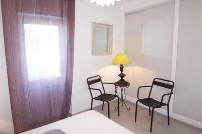 a room with two chairs and a table and a lamp at Appartement Chiola-Plage à pieds-clim in Solaro
