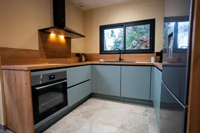 a kitchen with blue cabinets and a sink and a window at A CASA DI LAURENA piscine chauffée proche St Florent in Vallecalle