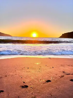 a sunset on a beach with the ocean at Maison de plage pour 10 personnes de 4 chambres front de mer Corse-du-Sud in Appietto