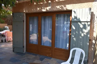 a pair of white chairs next to a wooden door at Maison de plage pour 10 personnes de 4 chambres front de mer Corse-du-Sud in Appietto