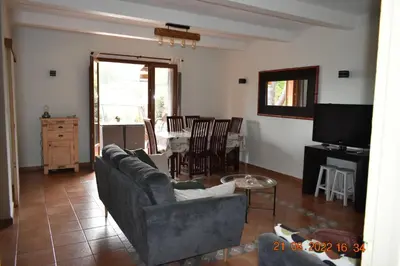 a living room with a couch and a tv and a table at Maison de plage pour 10 personnes de 4 chambres front de mer Corse-du-Sud in Appietto