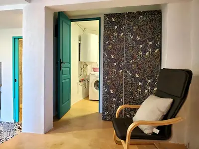 a room with a green door and a chair at Studio 2A in Ucciani