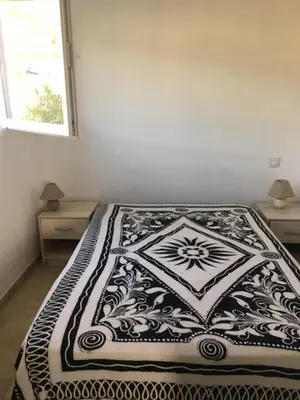 a black and white bed in a bedroom with a window at Appartement proche des plages in Porto-Vecchio
