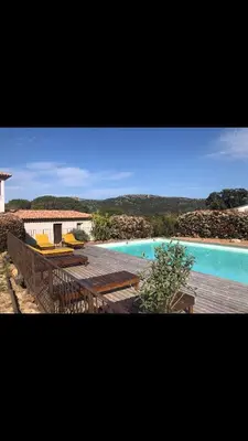 a view of a swimming pool with a deck and a swimming pool at Appartement proche des plages in Porto-Vecchio