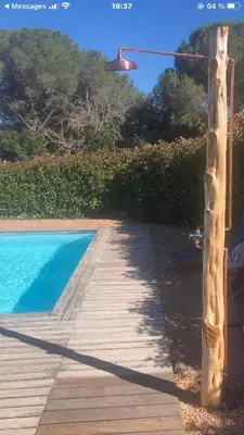 a wooden walkway next to a pool with a light at Appartement proche des plages in Porto-Vecchio