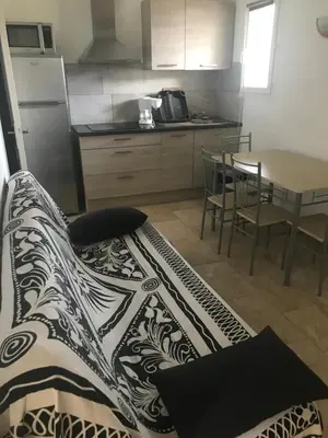 a kitchen with a table and a dining room at Appartement proche des plages in Porto-Vecchio