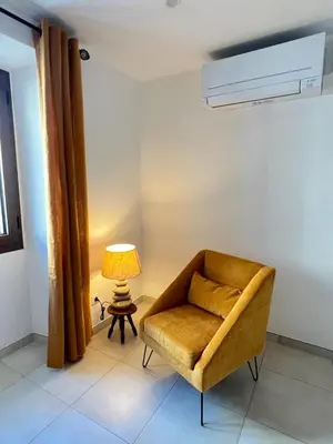 a living room with a chair and a lamp at A COLETTA in Piana