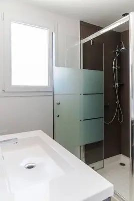 a bathroom with a white sink and a shower at Villa 4 personnes U Pinu, piscine partagée, 6 kms de porto vecchio in Porto-Vecchio
