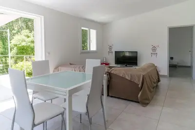 a dining room with a white table and chairs at Villa 4 personnes U Pinu, piscine partagée, 6 kms de porto vecchio in Porto-Vecchio