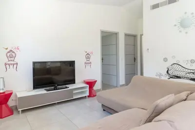a living room with a couch and a flat screen tv at Villa 4 personnes U Pinu, piscine partagée, 6 kms de porto vecchio in Porto-Vecchio