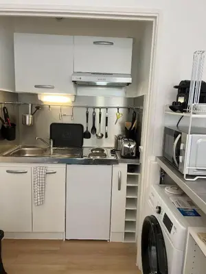 a small kitchen with white cabinets and a sink at Super Studio centre ville d'Ajaccio in Ajaccio
