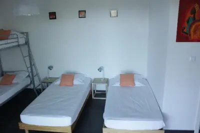 two beds in a dorm room with orange pillows at Villa Maremuntagna Porto Vecchio in Porto-Vecchio