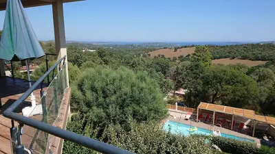 a view from the balcony of a resort with a swimming pool at Villa Maremuntagna Porto Vecchio in Porto-Vecchio