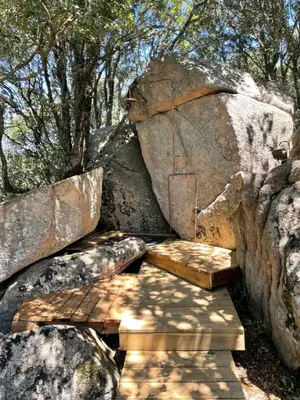 a wooden bench in front of a large rock at CORSICA NATURA #1 in Coti-Chiavari