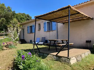 a patio with a picnic table and a roof at Gîte chez Arthur in Vezzani