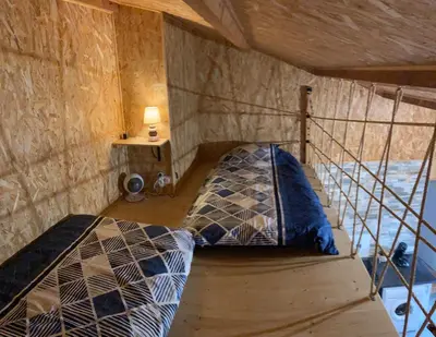 a bedroom with a bed in a room with a table at Gîte chez Arthur in Vezzani