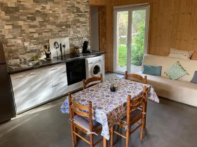 a kitchen and dining room with a table and a couch at Gîte chez Arthur in Vezzani